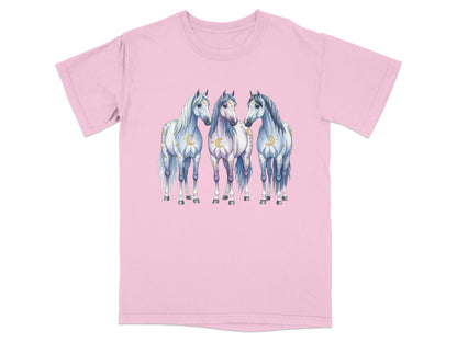 Three white horses with crescent moons and stars design on a pink t-shirt.