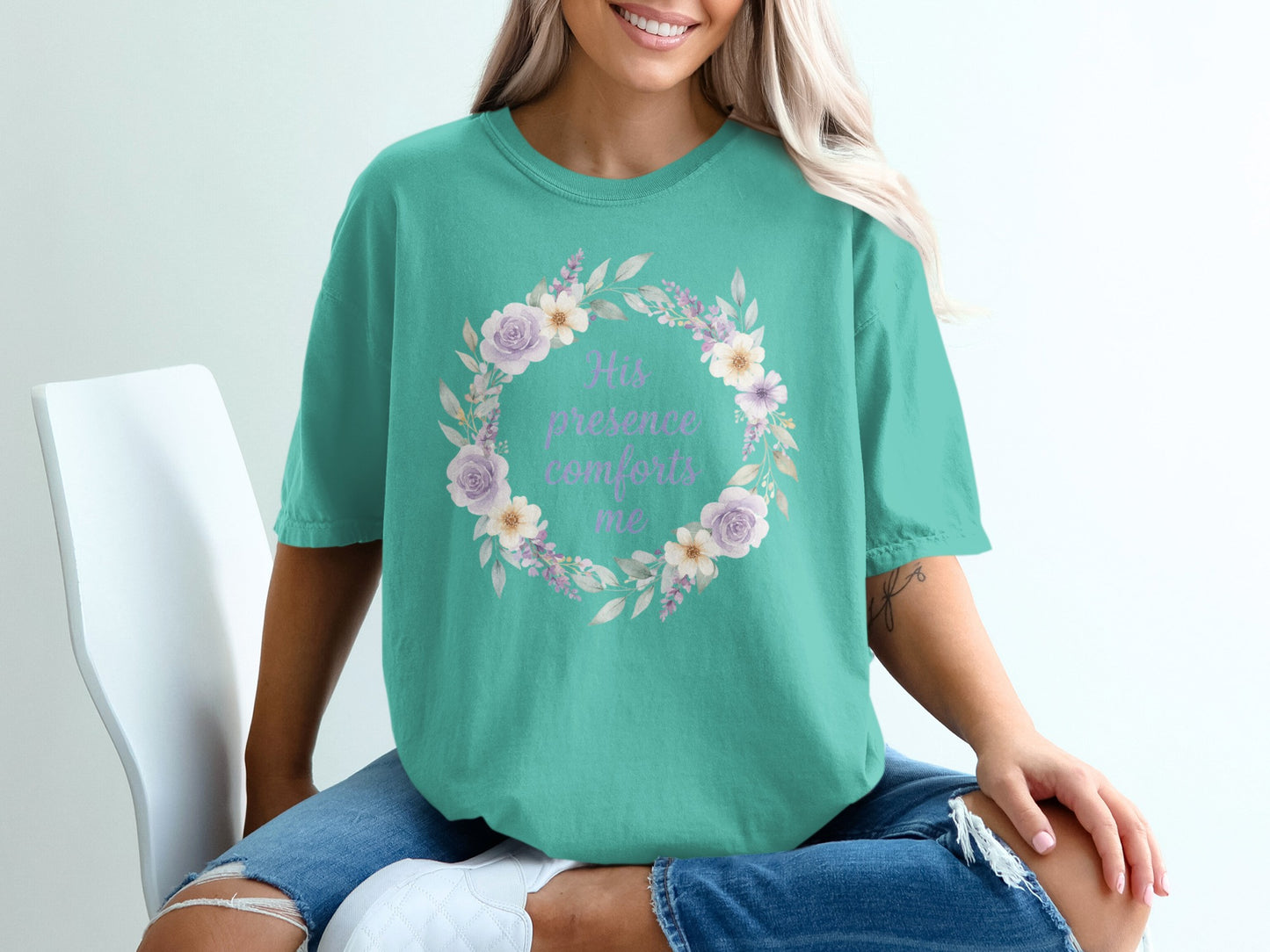 Teal t-shirt with purple floral wreath and "His presence comforts me" text.
