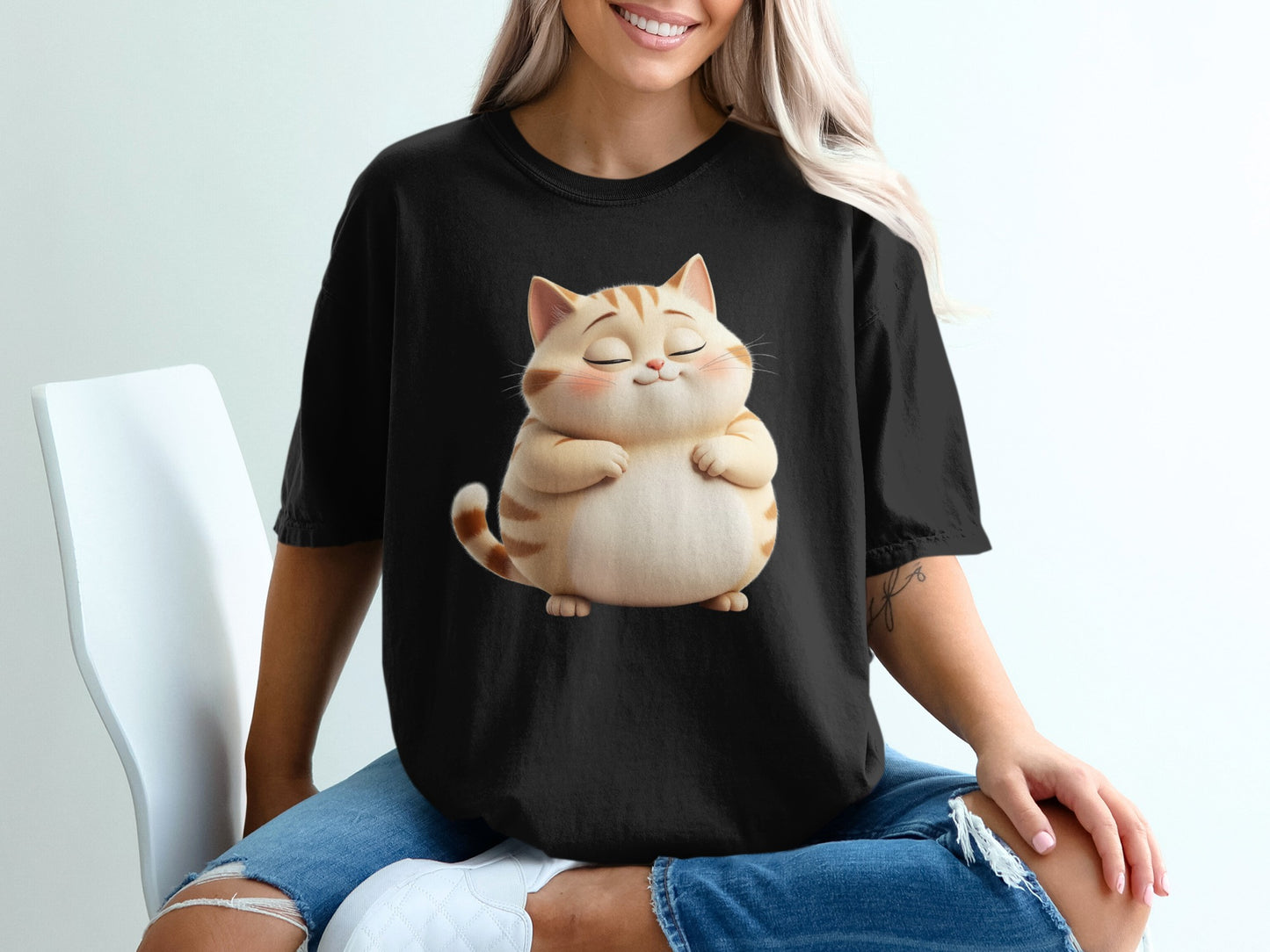 Black t-shirt featuring a cute, chubby cartoon cat with eyes closed.