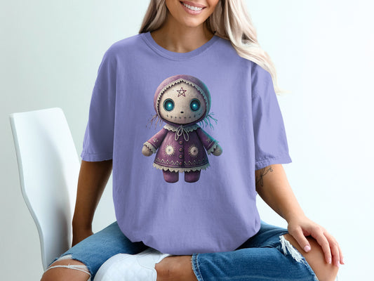 Purple t-shirt with a cartoon doll graphic featuring stitches and a star.