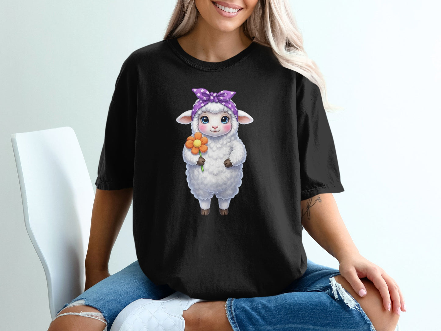 Cute sheep with flower and purple bandana on black t-shirt.