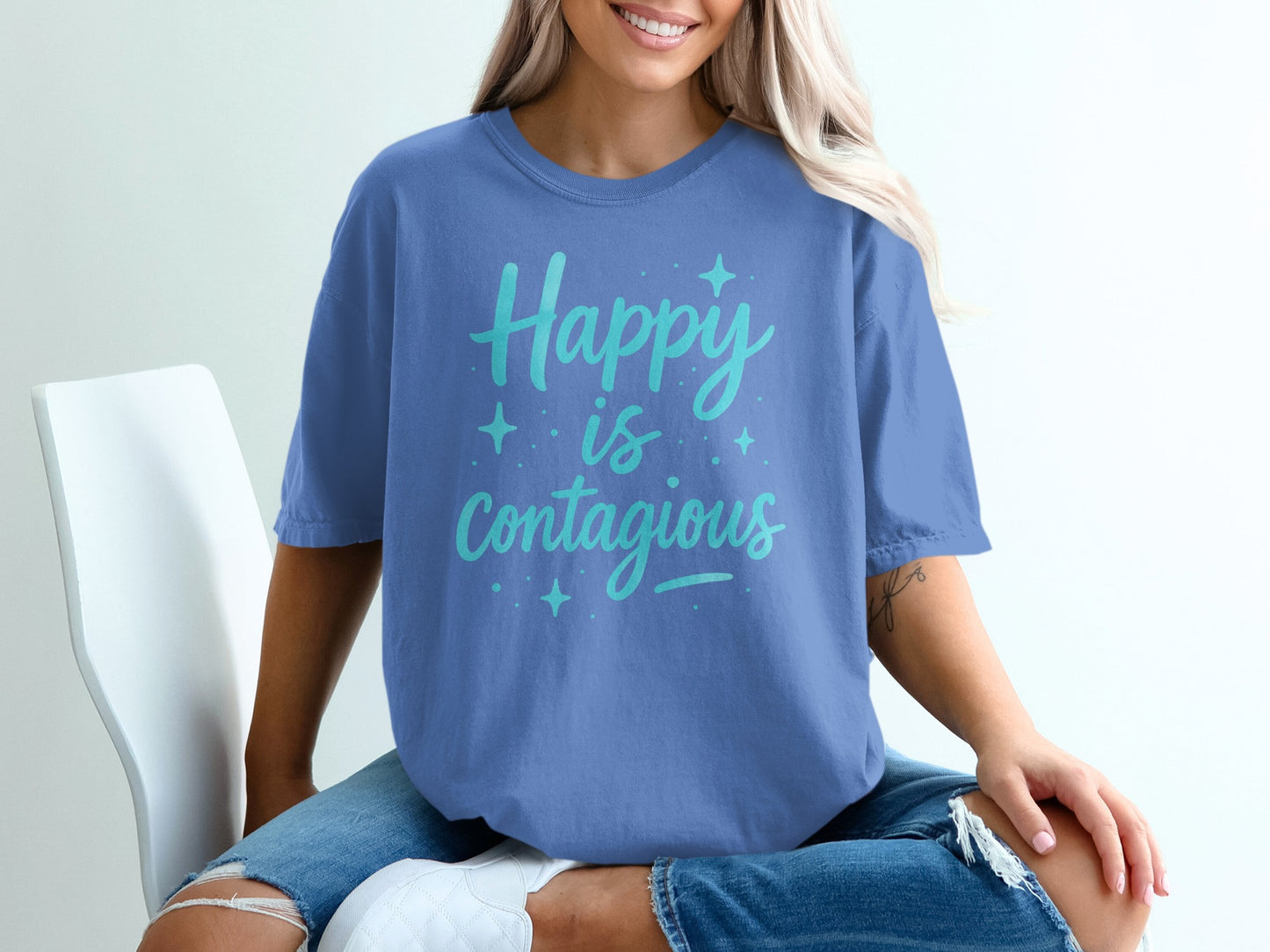 Blue t-shirt with "Happy is Contagious" text and star accents.
