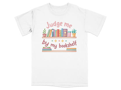 White t-shirt with "Judge me by my bookshelf" text and colorful books.