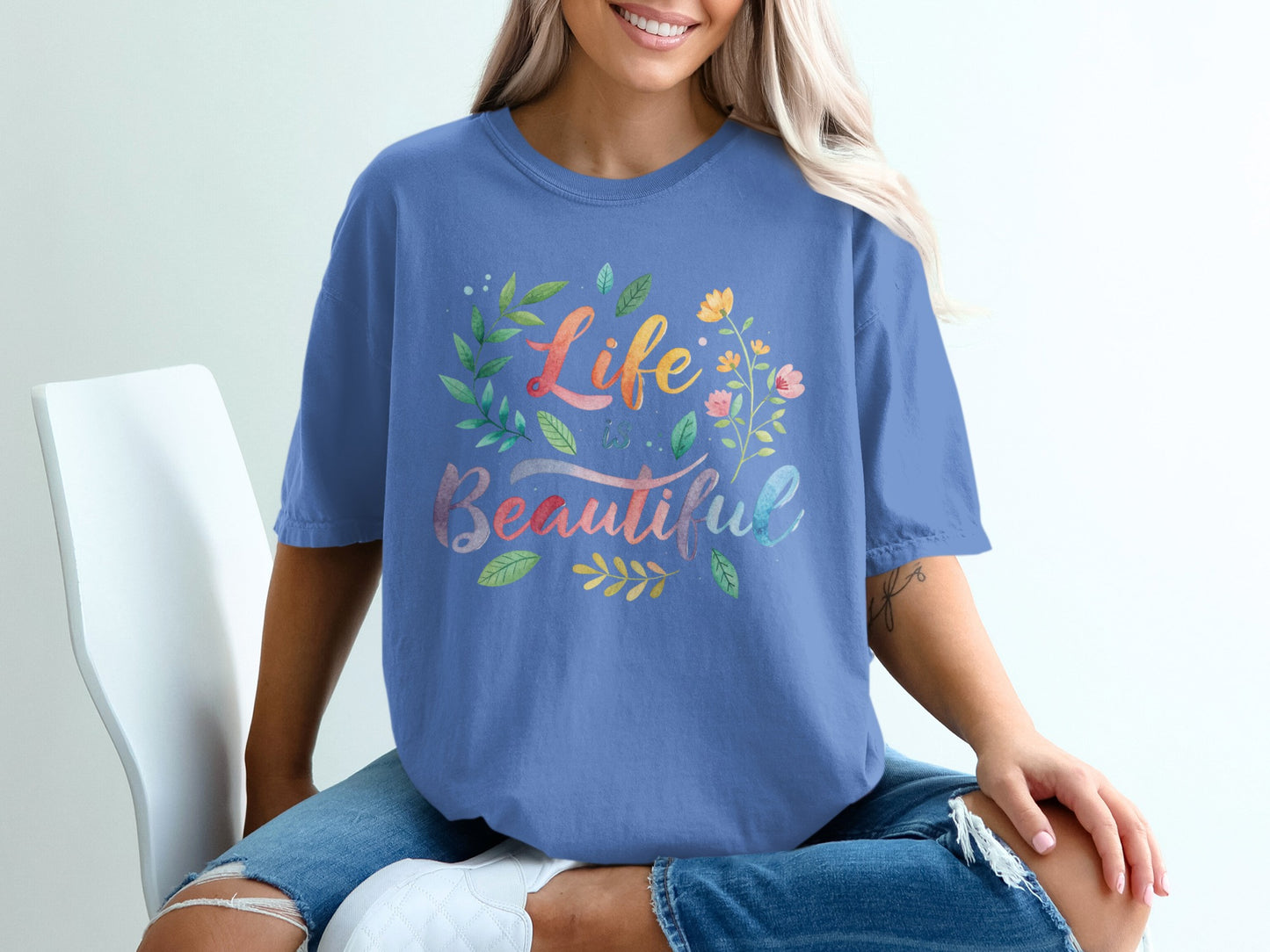 Blue t-shirt with watercolor floral design and "Life is Beautiful" text.