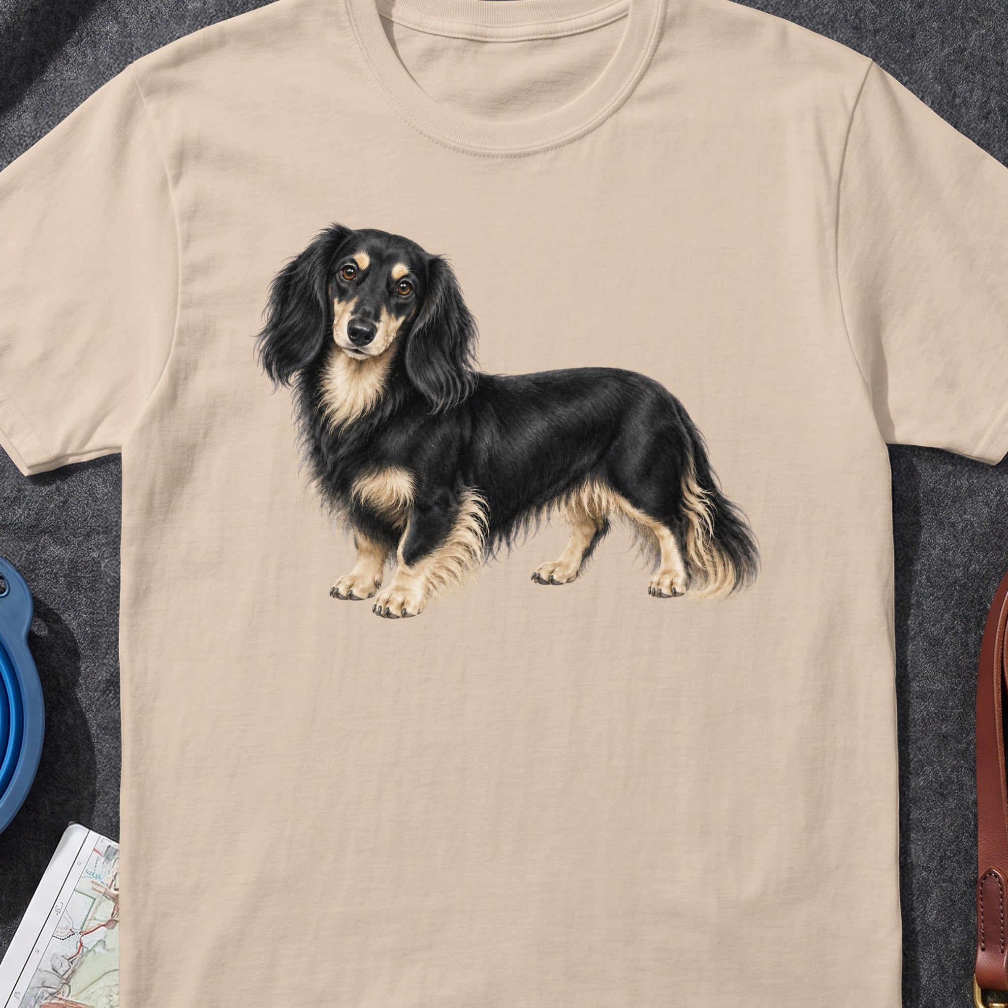Long-haired black and tan dachshund dog illustration on a light beige t-shirt.
