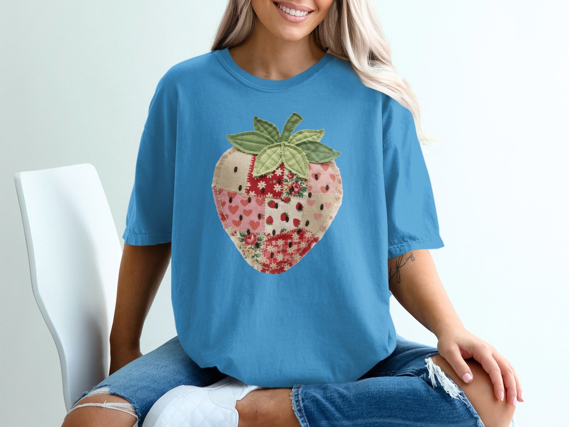 Blue t-shirt with a patchwork strawberry graphic.