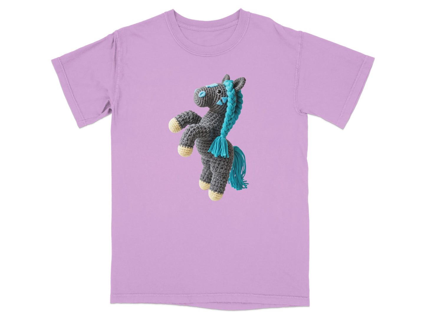 Crocheted grey pony with blue yarn mane and tail on a lavender t-shirt.