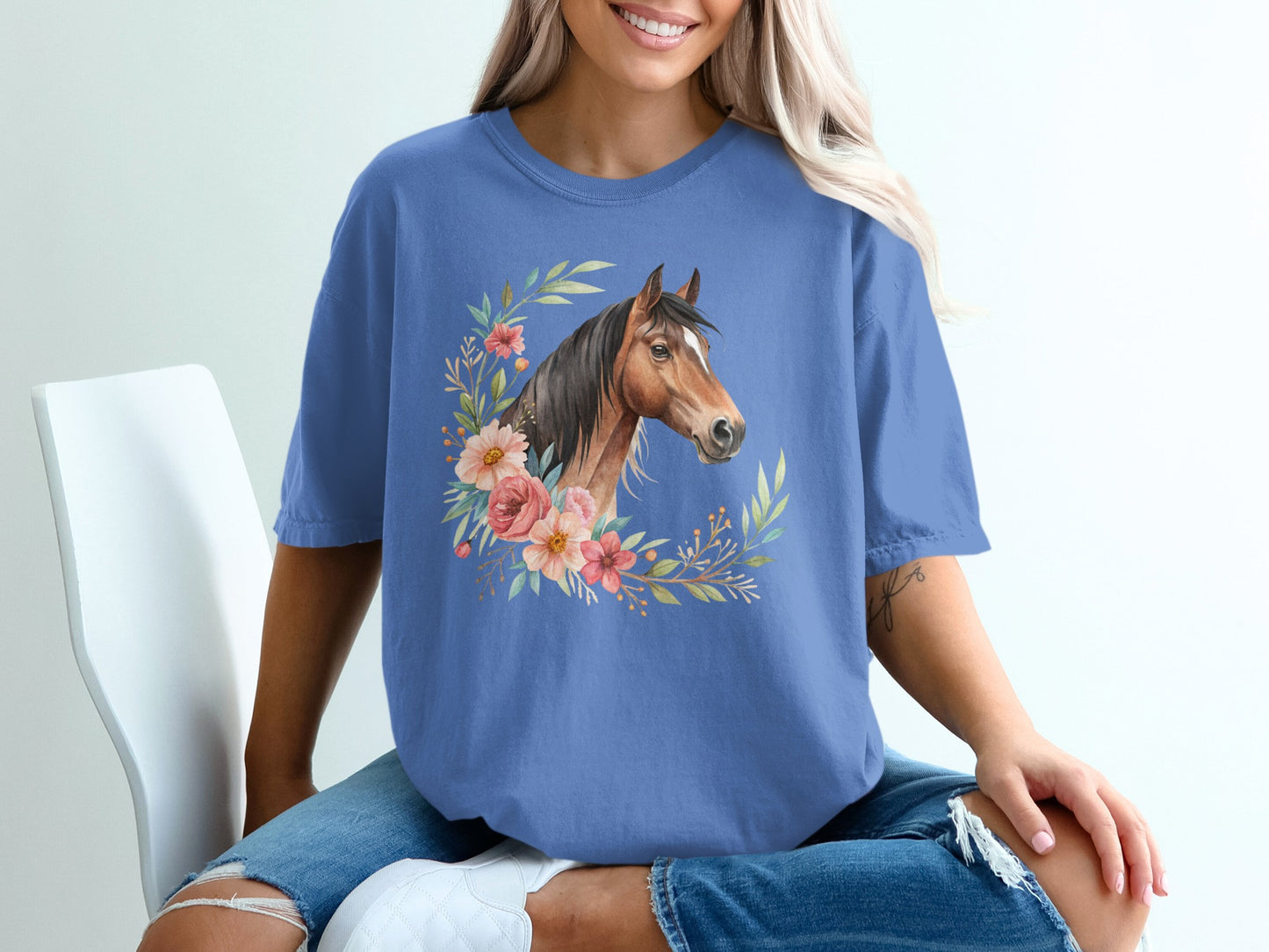 Blue t-shirt featuring a horse's head surrounded by floral elements.