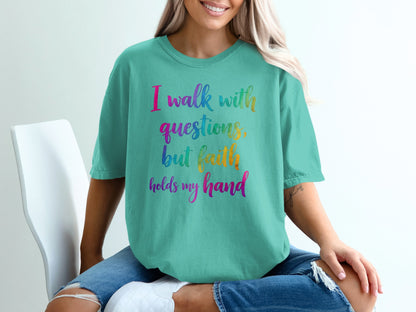 Teal t-shirt with colorful text: "I walk with questions, but faith holds my hand."