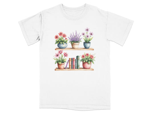 White t-shirt with watercolor art of two shelves with flowers and books.