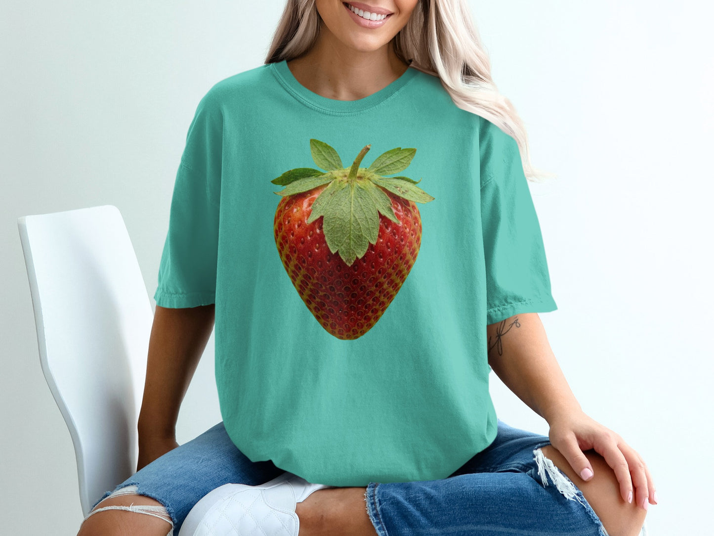 Teal t-shirt with realistic strawberry graphic on chest.