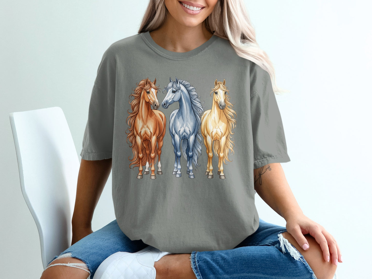Three horses, one brown and two white, on a gray t-shirt.
