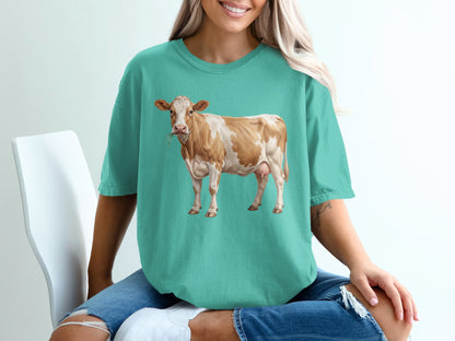 Teal t-shirt with a brown and white cow illustration.