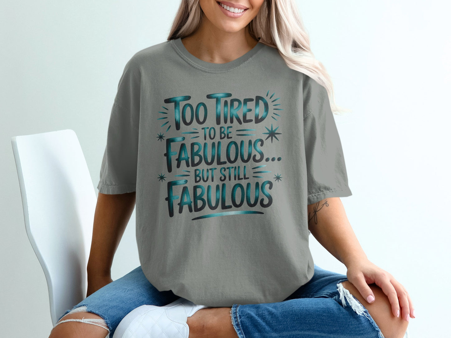 Grey t-shirt with teal text reading "Too tired to be fabulous... but still fabulous."