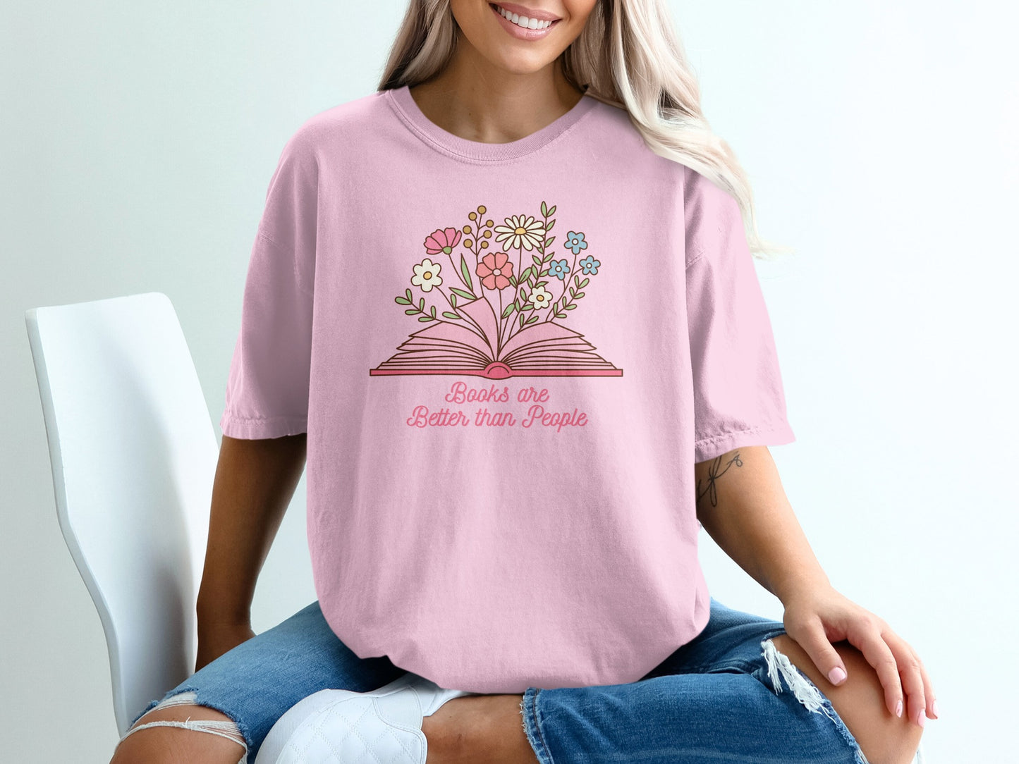 Pink t-shirt with an open book and floral illustration, reading "Books are better than People".