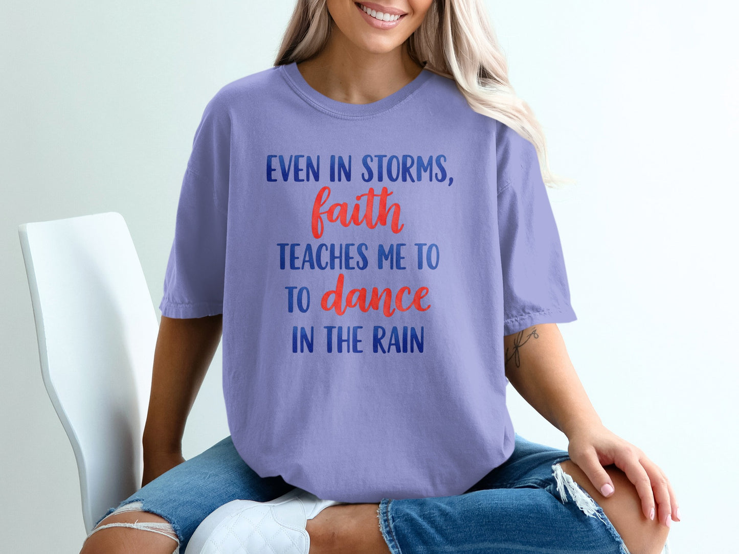 Purple t-shirt with text "Even in storms, faith teaches me to dance in the rain".