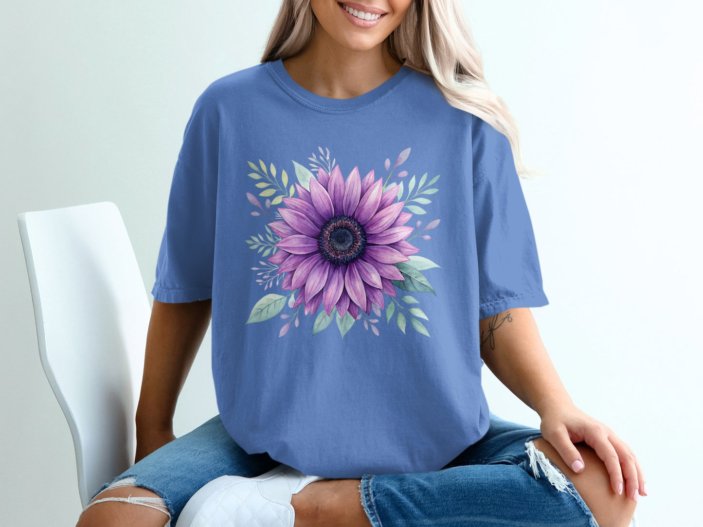 Periwinkle t-shirt with a large purple sunflower and green leaves graphic.