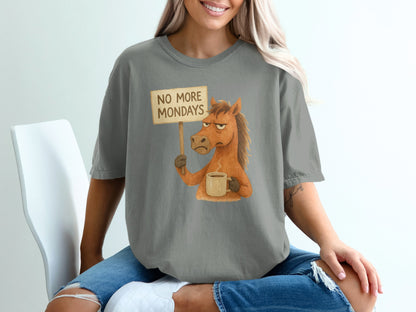 Horse holding "No More Mondays" sign and coffee mug, cartoon graphic on grey t-shirt.