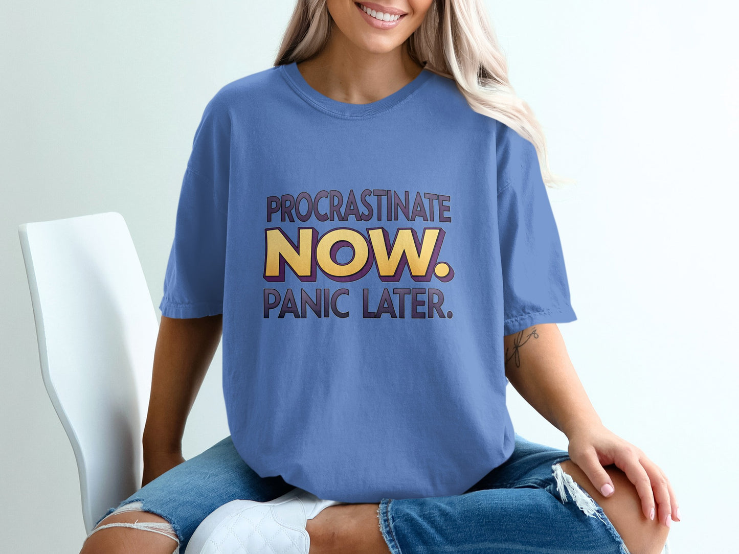 Periwinkle t-shirt with "PROCRASTINATE NOW. PANIC LATER." text in yellow and purple.