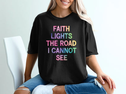 Black t-shirt with "FAITH LIGHTS THE ROAD I CANNOT SEE" in colorful text.
