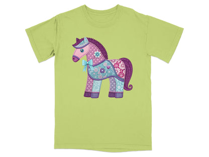 Quilted unicorn with floral and paisley patterns on a light green t-shirt.