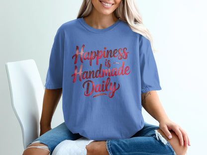 Blue t-shirt with "Happiness is Handmade Daily" text.