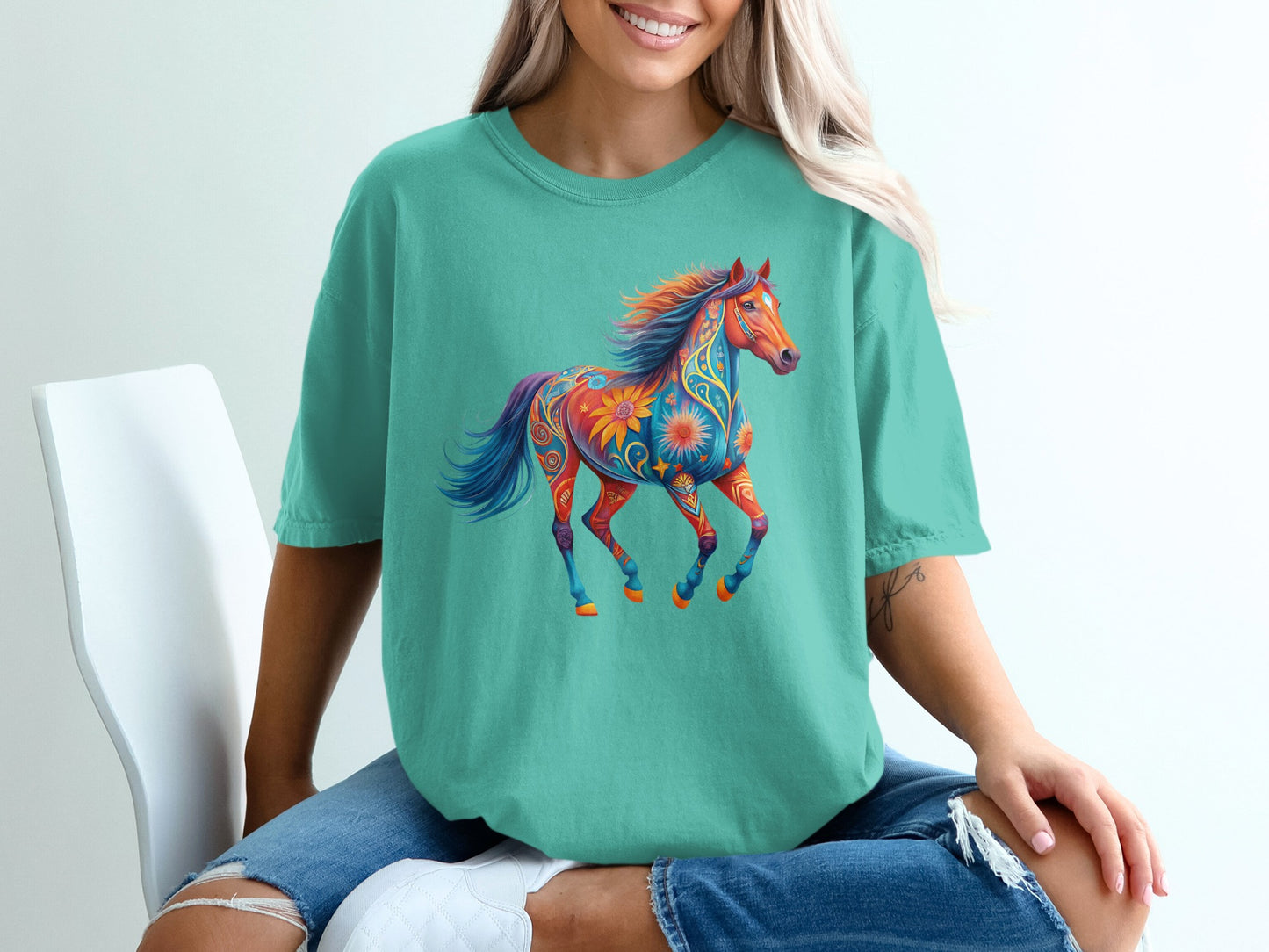 Teal t-shirt with a colorful, decorative horse graphic.
