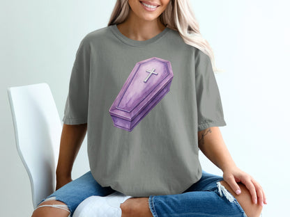 Purple coffin graphic with a cross on a gray t-shirt.