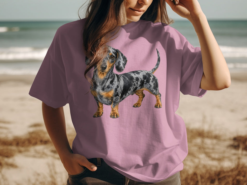 Dachshund graphic on a pink t-shirt worn by a person at the beach.