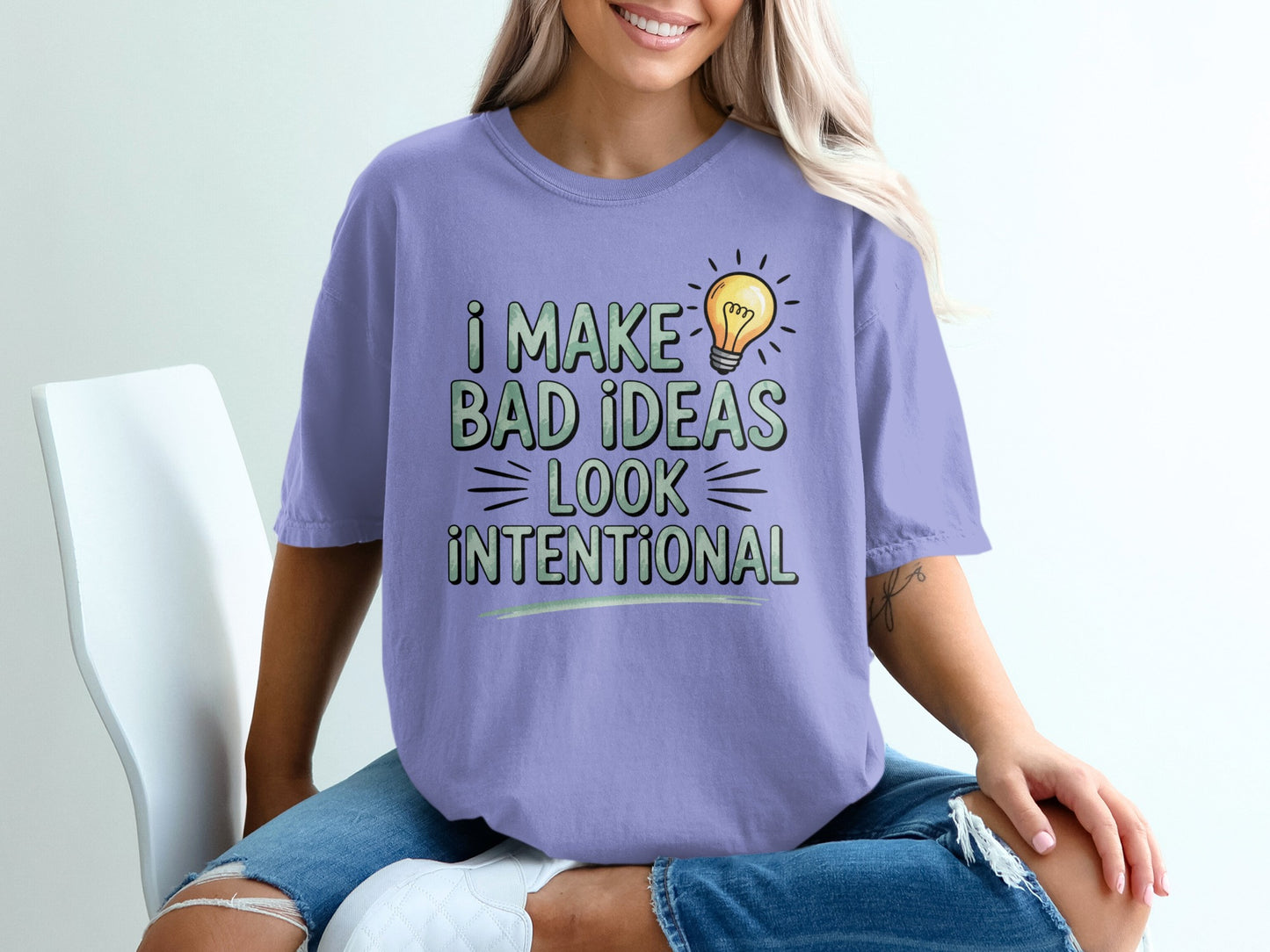 Purple t-shirt with text "I MAKE BAD IDEAS LOOK INTENTIONAL" and a lightbulb.