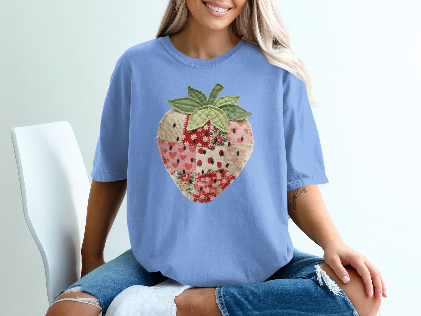 Blue t-shirt with a patchwork strawberry graphic design.