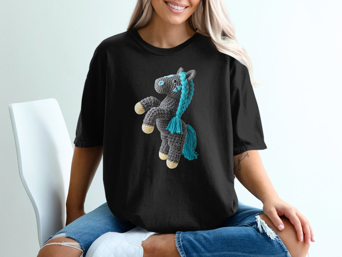Black t-shirt with a crocheted horse graphic featuring blue mane and tail.