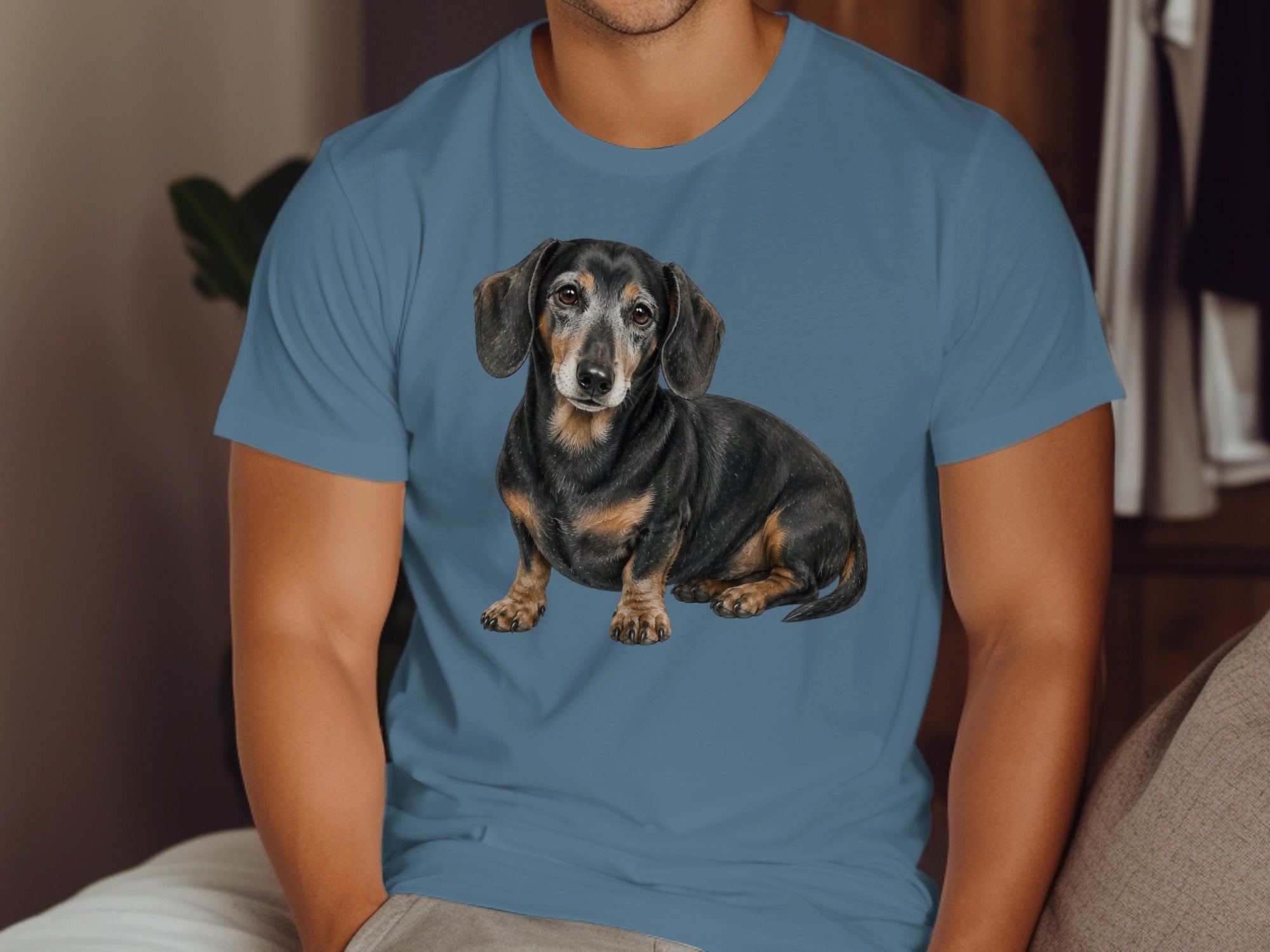 Blue t-shirt with a painting of a short-haired dachshund on the front.