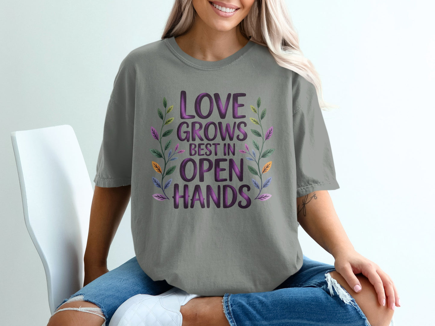 Gray t-shirt with "Love Grows Best in Open Hands" text and floral design.