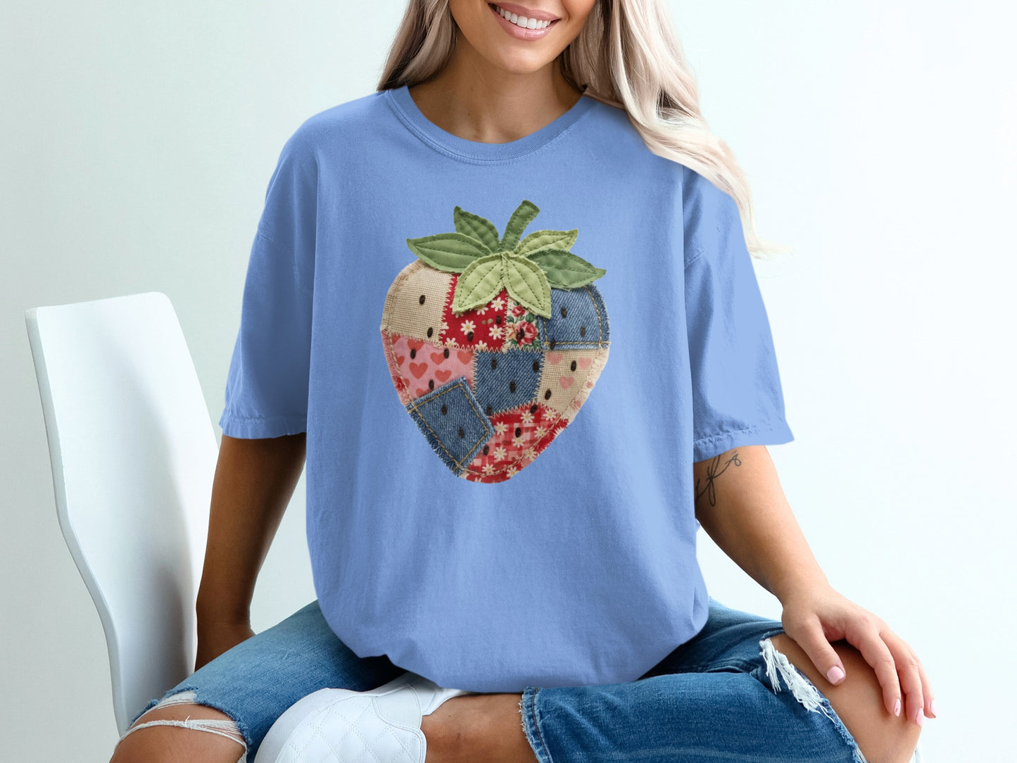 Blue t-shirt with a quilted strawberry graphic on the front.