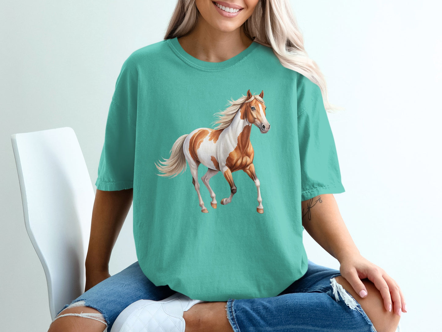 Teal t-shirt with a galloping horse graphic.