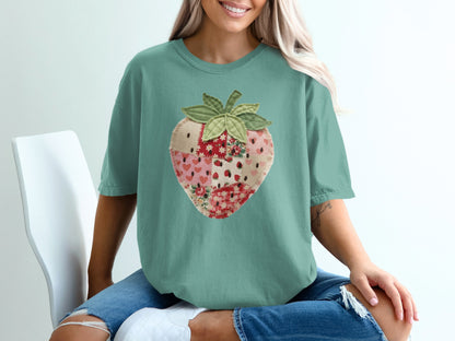 Teal t-shirt with a patchwork strawberry graphic.