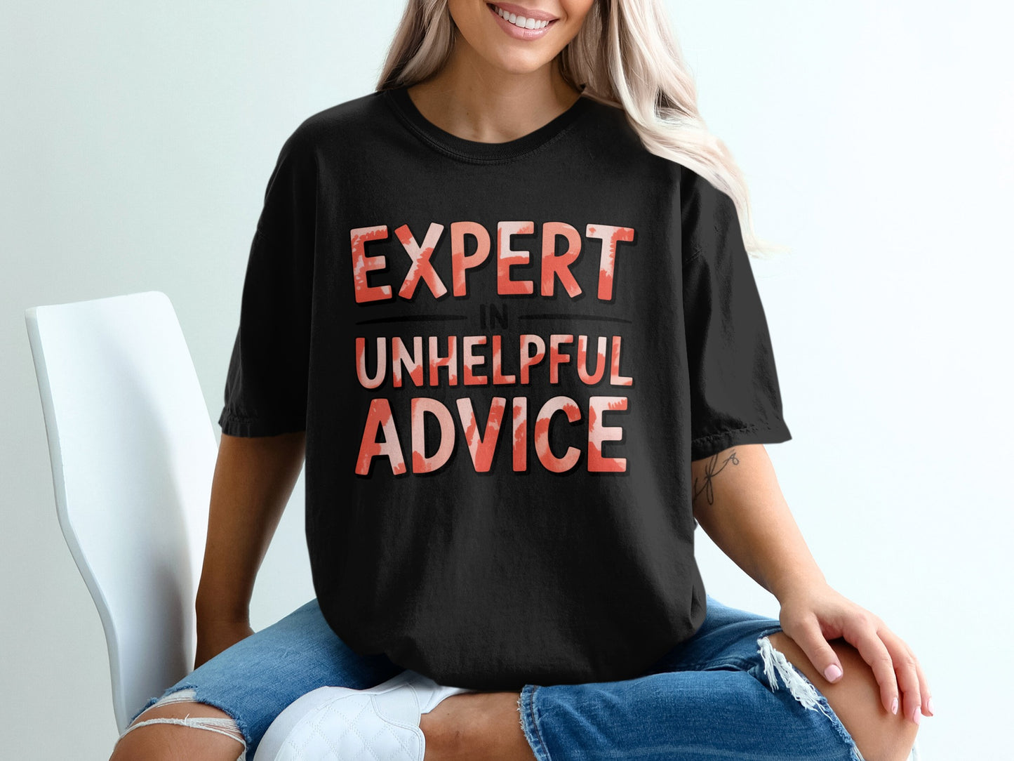Black t-shirt with "EXPERT IN UNHELPFUL ADVICE" text in red and orange.