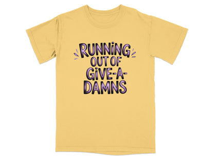 Yellow t-shirt with "RUNNING OUT OF GIVE-A-DAMNS" in purple lettering.
