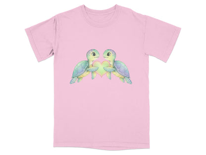 Two sea turtles hold a heart, printed on a pink t-shirt.