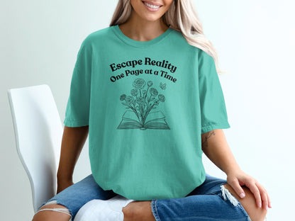 Teal t-shirt with open book and flowers, text "Escape Reality One Page at a Time".