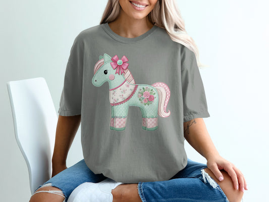 Pastel horse graphic with pink bow on a grey t-shirt.
