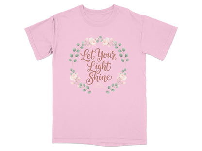 Pink t-shirt with "Let Your Light Shine" text inside a floral wreath.