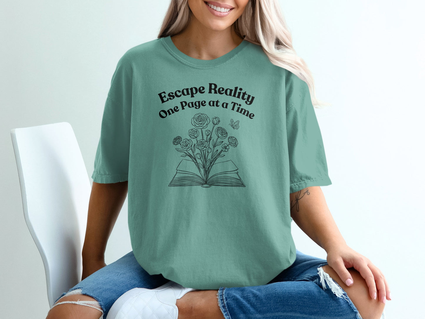Green t-shirt with "Escape Reality One Page at a Time" and open book with flowers design.