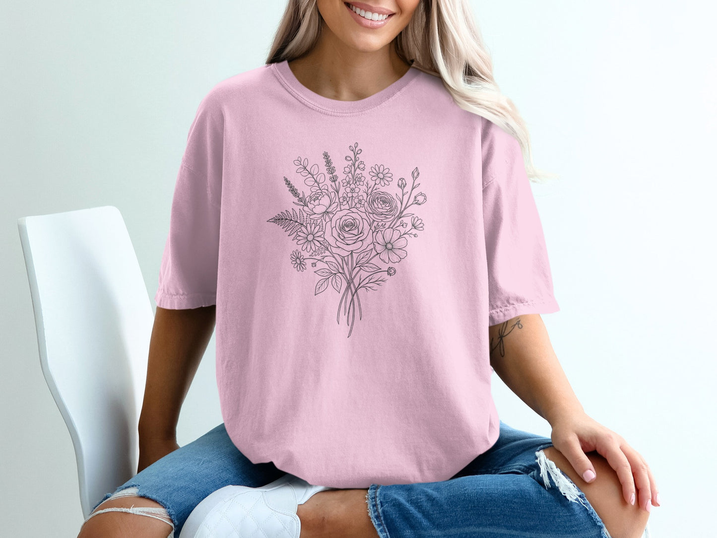 Pink t-shirt with a delicate line drawing of a floral bouquet.