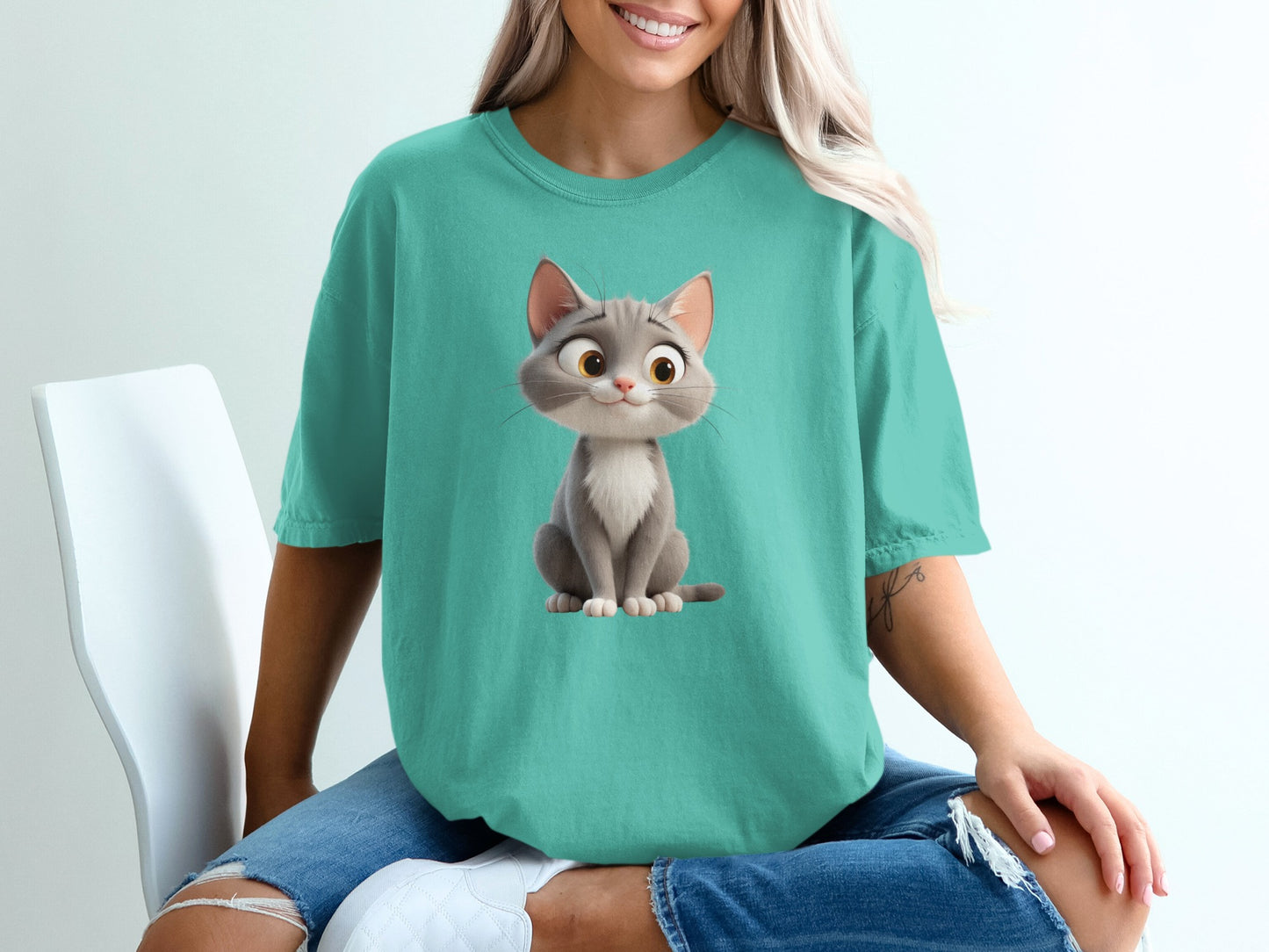 Teal t-shirt with cartoon cat graphic, worn by a woman.