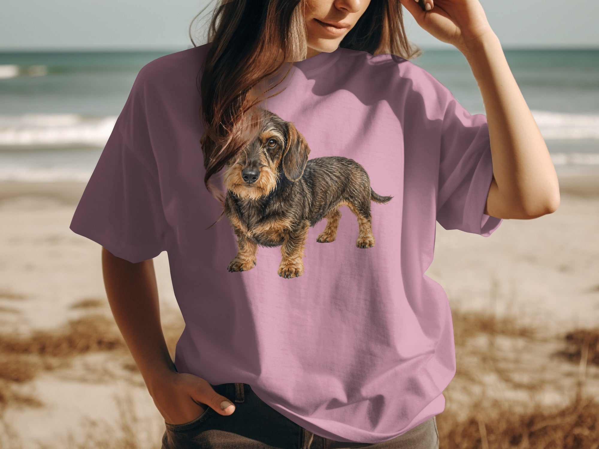 T-shirt with a printed image of a wirehaired dachshund on a beach background.