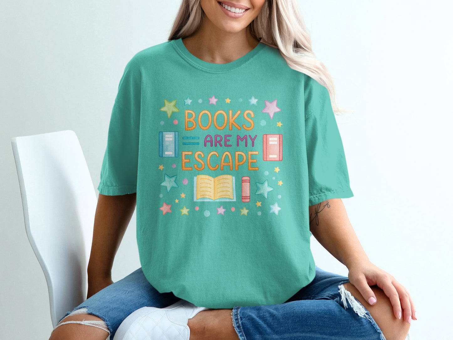 Teal t-shirt with "Books Are My Escape" in colorful lettering and book graphics.