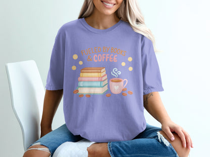 Purple t-shirt with books, coffee cup, and text "Fueled by Books & Coffee".