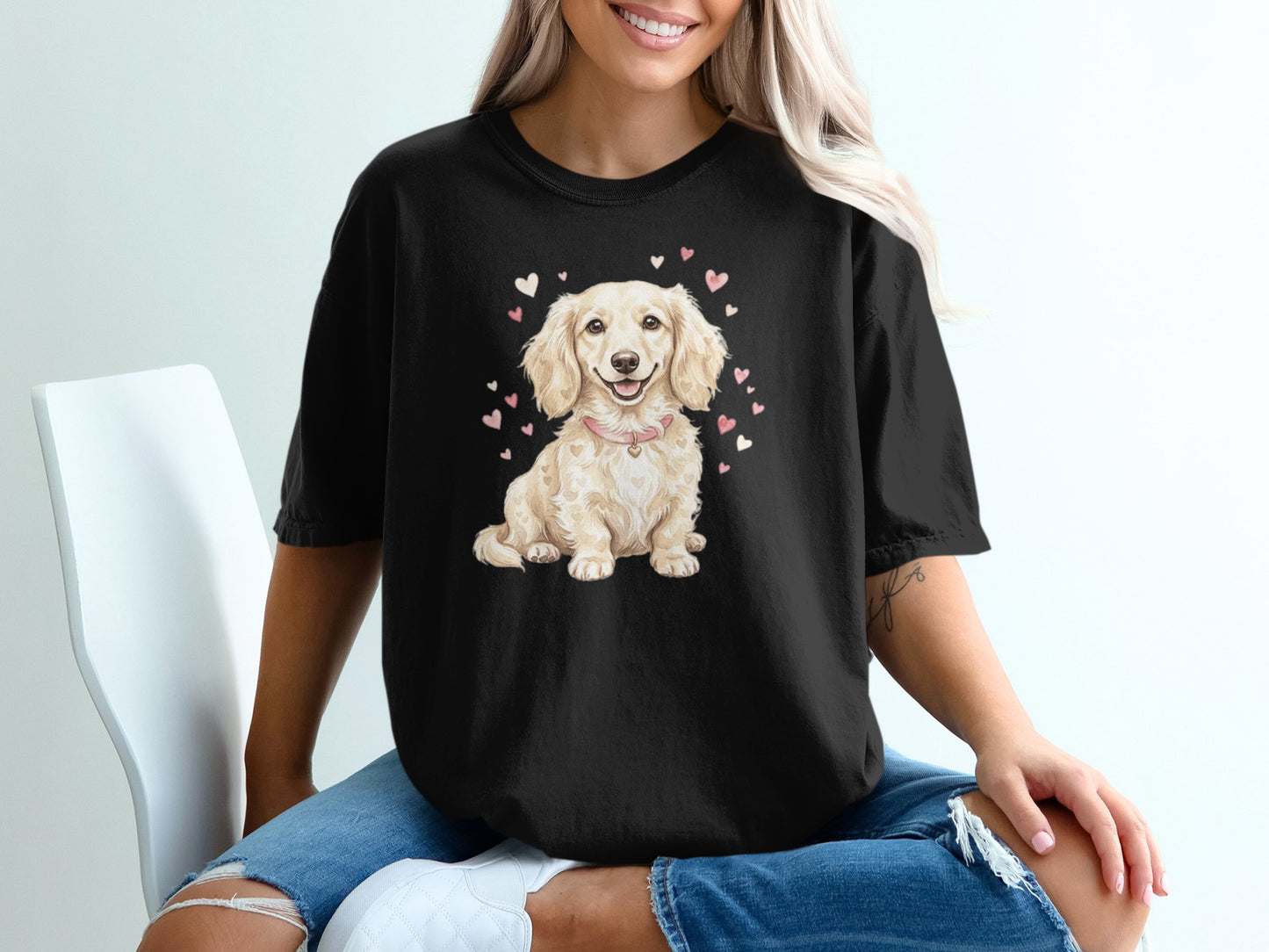 Black t-shirt featuring a light-colored dachshund surrounded by pink hearts.